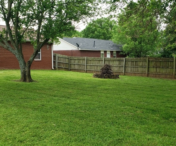 The backyard of a client of Riverview Turfworks in Van Buren AR. The grass is green and healthy and has been prefessionally cut.