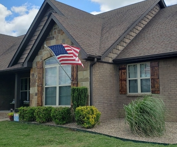 A home in Van Buren that has been serviced by Riverview Turfworks. The grass has been mowed, and the landscape beds around the front door have fresh mulch and pruned shrubs.